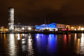 Lorient Morbihan Harbor waterfront at night with striking blue lights reflecting on the sea surface.