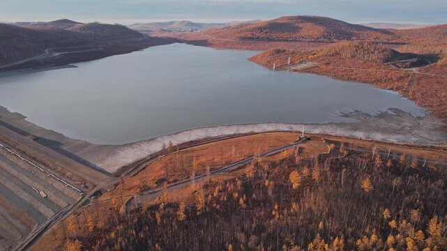 Panoramic aerial view of gold mining waste tailings storage facility, water lake and autumn landscape.