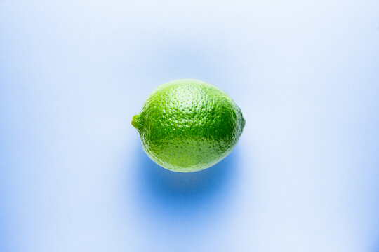 Fresh bright green lime on a blue background.
