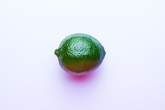 Fresh bright green lime on a pink background.