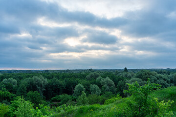 A cloudy dawn gently unfolds over a picturesque village in the Poltava region of Ukraine, casting a soft light on the rural landscape.