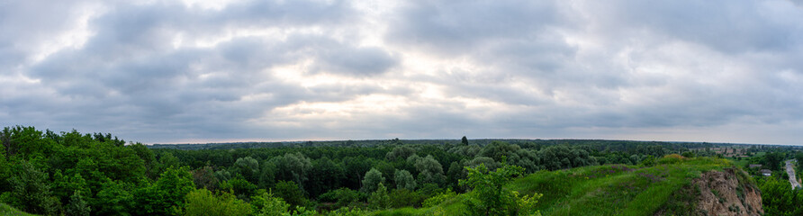 A cloudy dawn gently unfolds over a picturesque village in the Poltava region of Ukraine, casting a soft light on the rural landscape.