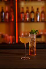 Cocktail in a tall glass against the background of a dark bar