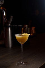 Orange cocktail in a glass goblet in a dark bar