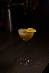 Orange cocktail in a glass goblet in a dark bar