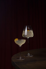 Cocktails in tall glasses on a bar counter in a dark bar