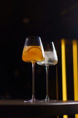 Orange cocktail in a glass goblet in a dark bar