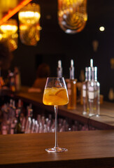 Cocktails in tall glasses on a bar counter in a dark bar