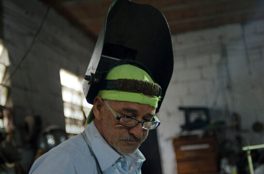 Welder wearing protective mask working in workshop