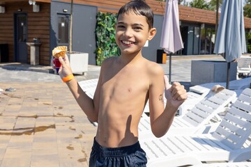 A joyful Hispanic boy, around 10 years old, enjoying ice cream by the poolside on a sunny day, with a thumbs-up gesture.