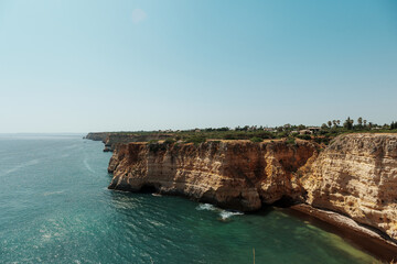 Golden Algarve cliffs with sea caves and turquoise waters, Portugal