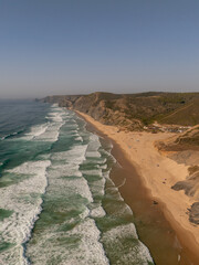 Aerial view of Praia da Amoreira with Atlantic waves and rugged Algarve cliffs, Portugal
