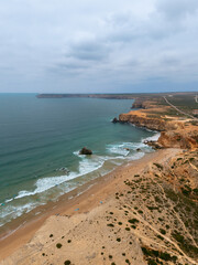 Aerial view of surfers and beach at Sagres cliffs, Algarve, Portugal
