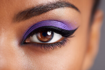 Fototapeta premium Extreme close-up of eye makeup with glossy purple eyeshadow and eyeliner