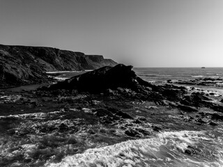 Black and white aerial view of rocky outcrop and Atlantic coastline, Algarve, Portugal