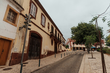 Cobbled street with historic buildings and balconies in Silves, Algarve, Portugal