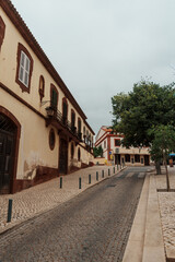 Narrow cobblestone street with historic buildings in Silves, Algarve, Portugal