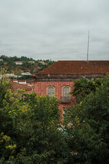 Old red brick building with tiled roof surrounded by greenery in Silves, Algarve, Portugal