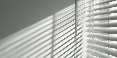 Obraz premium Shadows of window blinds cast upon a clean white wall. Sense of peaceful simplicity and modern design.