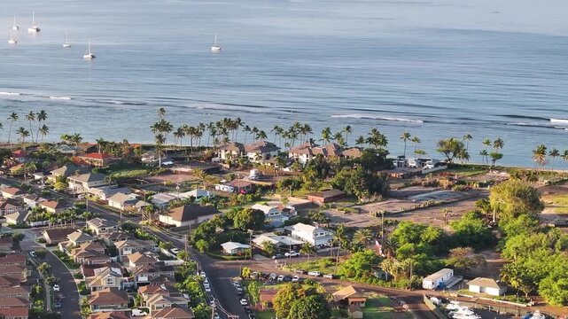 Aerial view of coastal town Lahaina, Maui, Hawaii not affected by wildfire with homes along ocean coast waves and palm trees landscape seascape - 4K Drone