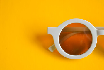 Trendy round glasses with pastel blue frames and brown lenses, edgy Y2K fashion accessory, modern retro eyewear on yellow background.