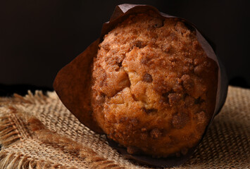 Closeup of a Coffee Cake Muffin on its side on burlap napkins.