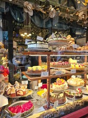 A Mouth-watering Display of Cakes and Pastries in a Patisserie Window