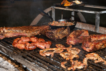 Primer plano asado carne Argentina en parrilla, con brozas
