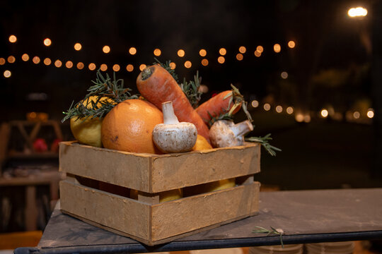Primer plano decoraci&oacute;n con verduras en caj&oacute;n de madera r&uacute;stico, de fonfo luces bokeh