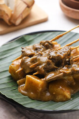 Sate padang. Padang satay made from beef with peanut curry sauce. served with lontong or rice cake. perfect for recipe, article, or any commercial purposes.