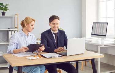 Business colleagues collaborate in an office, working together on accounting tasks using a laptop during a meeting. The discussion promotes teamwork and effective business operations.