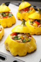 Tasty stuffed pattypan squashes on baking sheet, closeup