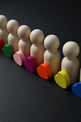 Tolerance concept. Human figures and colorful hearts on black background, closeup