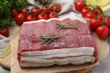 Piece of raw beef meat, tomatoes and spices on table, closeup