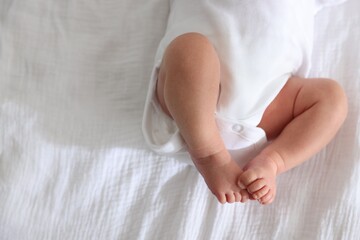 Cute newborn baby lying on bed, top view. Space for text