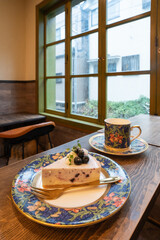 雨の日のカフェの窓辺　ブルーベリーのレアチーズケーキでティータイム
