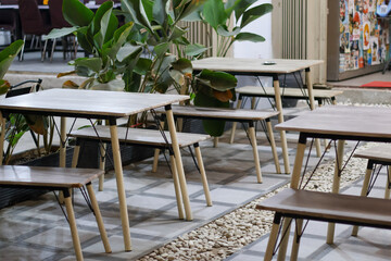 Empty table and chair in coffee shop cafe and restaurant, Empty modern cafe interior with wooden tables and warm cozy light setting.