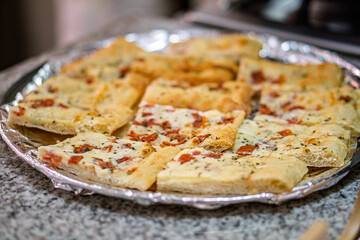 Chef preparing delicious garlic bread with cheese and tomatoes for lunch
