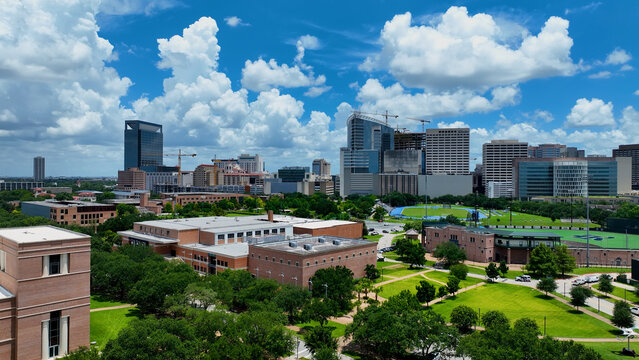 Houston, Texas USA - 7 11 2025: Aerial drone Photograph of Rice University. Clear view of TMC. Stunning blue sky and powerful white clouds hover above stadium in summer sunshine.