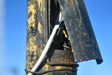 Damaged wires. Aluminum bare wires of electric cable or duct tape torn beside concrete poles. Selective focus