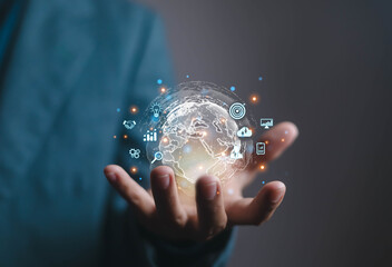 Businessman hand holding digital globe with futuristic technology icons, representing global business strategy, innovation, artificial intelligence, data analysis, cloud computing