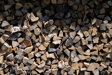 Pile of firewood logs stacked neatly in natural sunlight