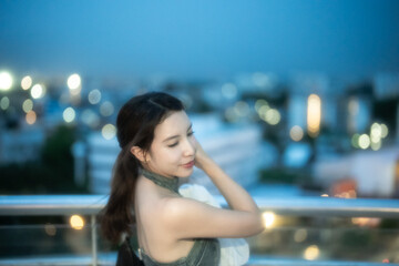 Sexy fashion woman posing in the night city with bokeh lights.