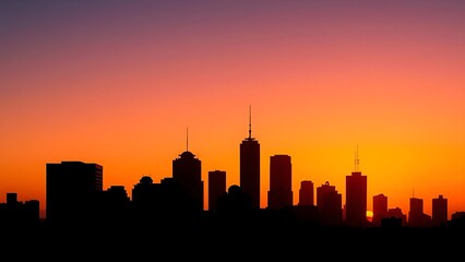 Fototapeta premium An abstract cityscape silhouette with geometric shapes and warm sunset colors.
