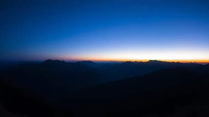 Mountain landscape bathed in twilight hues of deep blue and fading sunset colors.
