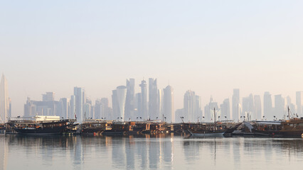 Fototapeta premium カタール・ドーハ コーニッシュの朝の景色 – ダウ船と近代的なスカイライン