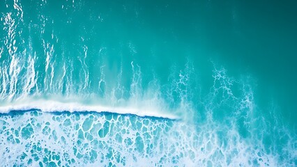 Aerial perspective of vibrant ocean waves under sunlight, creating a serene and minimalist seascape.