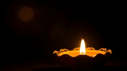 A golden oil lamp glows warmly against a dark backdrop, its flickering flame creating a cozy atmosphere.