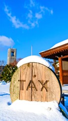 Snowy scene with wooden sign, temple, and tower