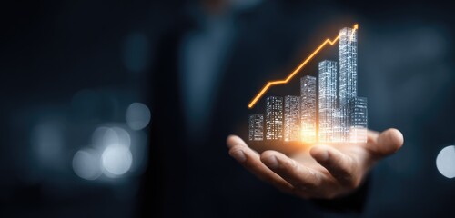 A hand holds a holographic graphic of a rising bar graph comprised of city structures